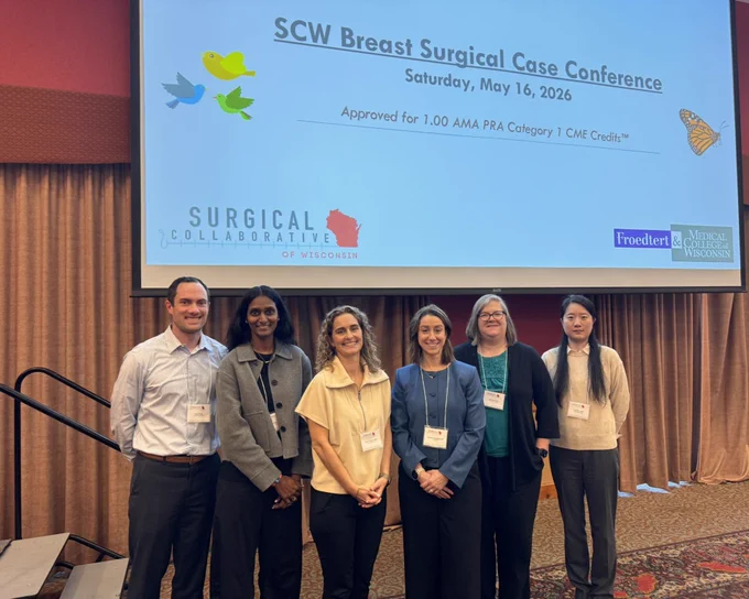 Dan Pung, Sudha Pavuluri Quamme, Elise Lawson, Meeghan Lautner, Randi Cartmill, and Ping Zhu stand together for a picture in front of a screen that says "SCW Breast Surgical Case Conference Saturday, May 16, 2026 Approved for 1.00 AMA PRA Category 1 CME Credits"