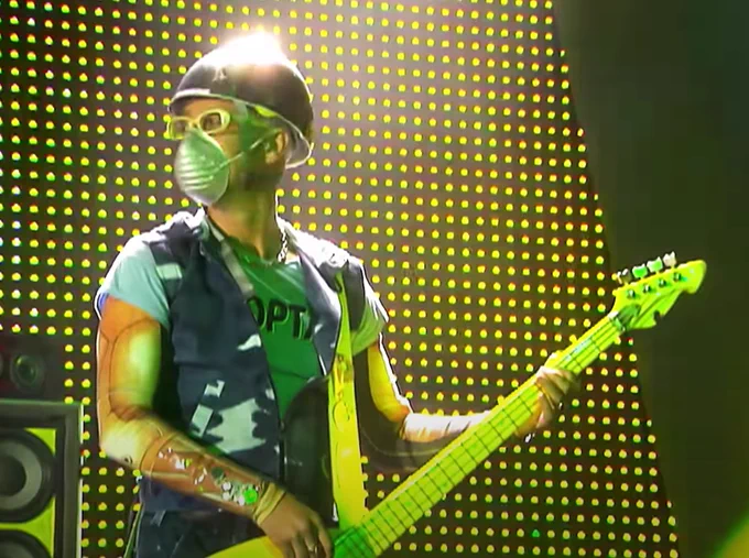 Adam wearing a helmet and face mask onstage during a Popmart show.