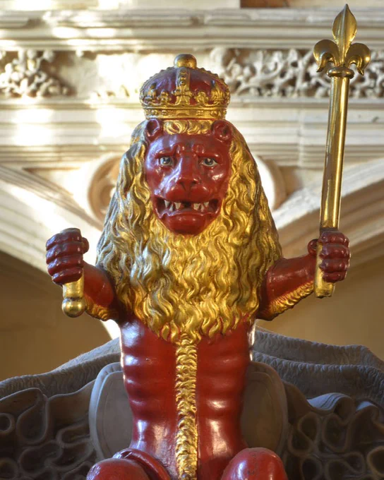 The figure of a red and gold lion, wearing a crown, stands at the feet of Mary Queen of Scots' tomb effigy in Westminster Abbey