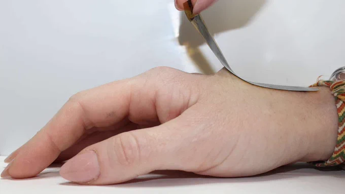 A wearable sensor is applied to the skin on a hand.