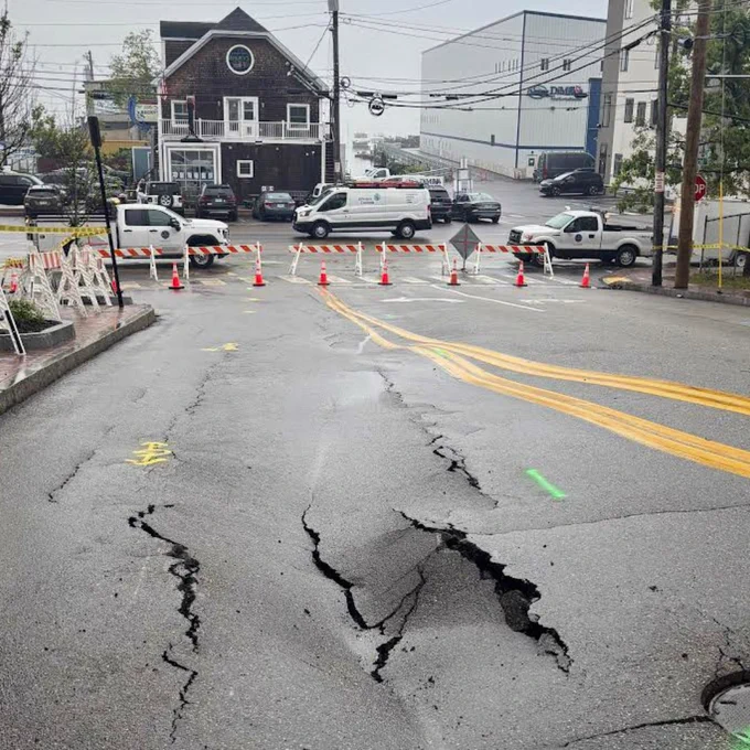 Road washout looking downhill towards Becky's diner with road blocks in place at Commercial street intersection
