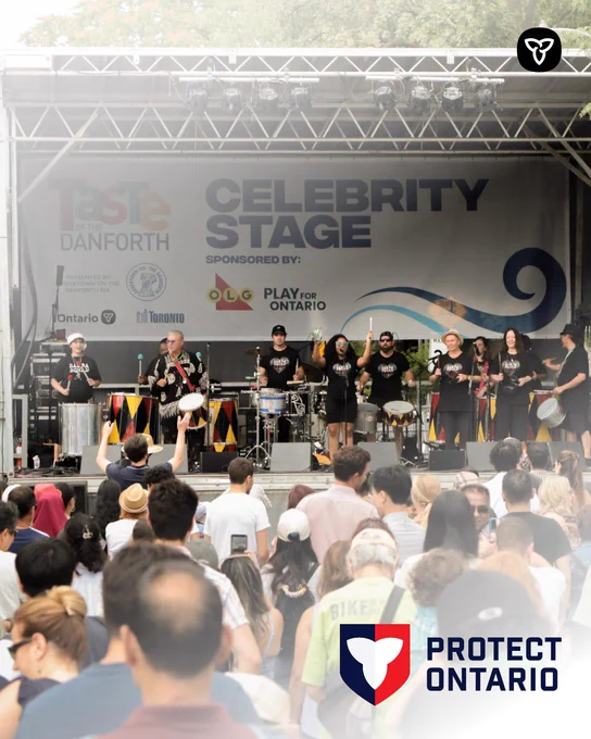 A live band performs on an outdoor stage at Taste of the Danforth, with a large banner reading “Celebrity Stage” and a crowd gathered in front. The Protect Ontario logo appears in the corner.