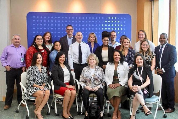 A large group photo with 20  adults smiling for the camera.