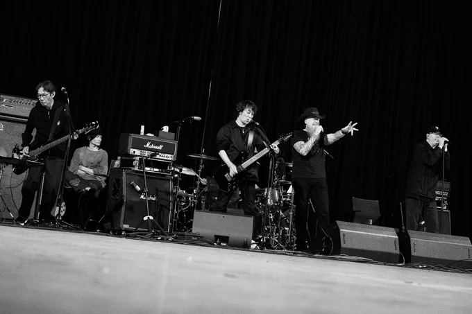 A black and white photograph of The Primals and Jason Charles Miller rehearsing.