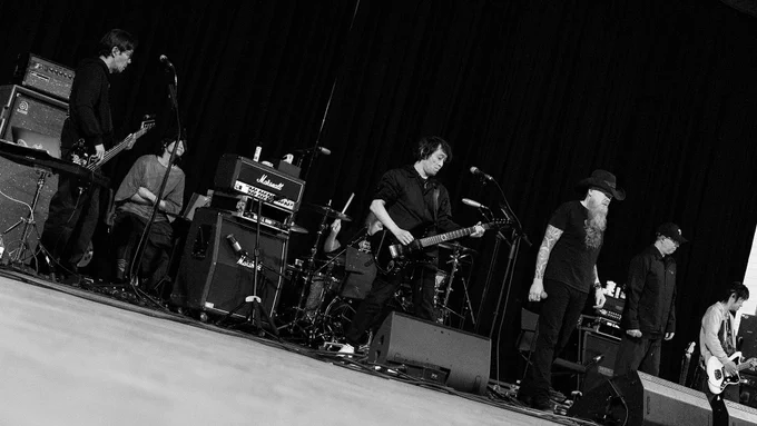 A black and white photograph of The Primals and Jason Charles Miller rehearsing.