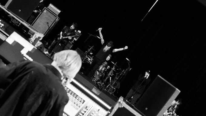 A black and white photograph of The Primals and Jason Charles Miller rehearsing.
