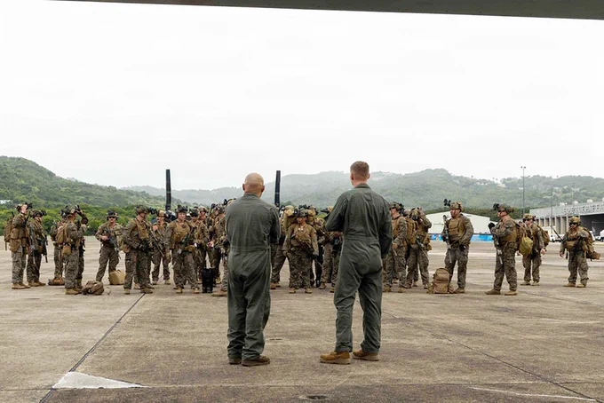 Marines receive a mission brief on an airfield before conducting aviation and ground operations with MV-22B Ospreys.