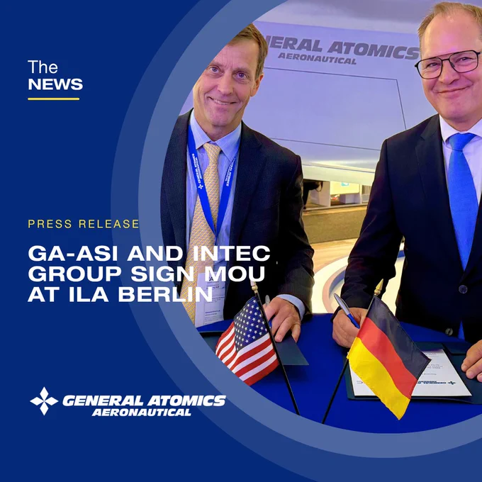 Two men in suits from General Atomics Aeronautical Systems and INTEC Group signing a memorandum of understanding at ILA Berlin Air Show, with American and German flags on the table.