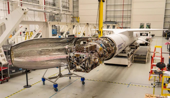 The Katalyst Space’s LINK robotic servicing satellite awaits encapsulation inside a Northrop Grumman Pegasus XL rocket. The rocket and satellite are inside a pale, indoor facility. Credit: NASA
