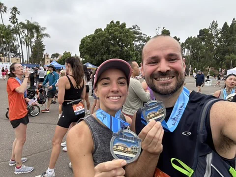 Jonathan Weitz and one other person at a race holding up medals