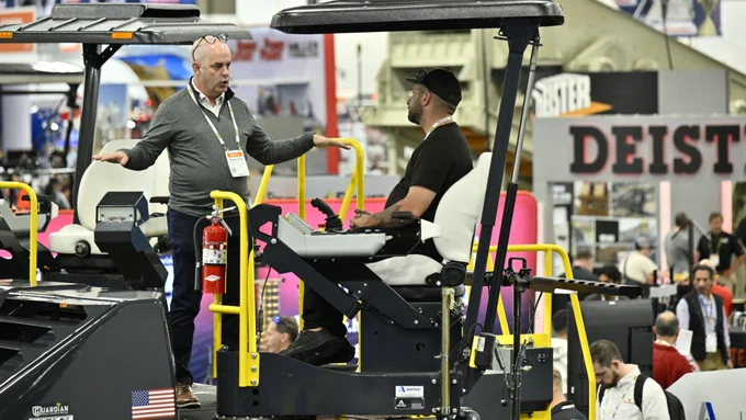 Two men talking to each other as one sits inside a crane at CONEXPO-CON/AG 2026.