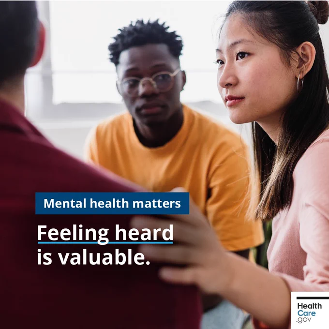 Chat in a bright room. Three people are sitting together. One person has a hand on another's shoulder in a supportive gesture. Text reads, "Mental health matters. Feeling heard is valuable." HealthCare.gov logo is in the corner.
