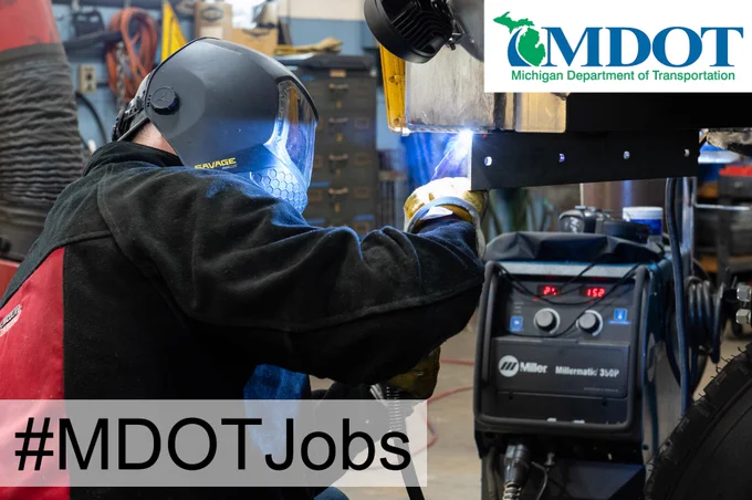 Welder at work on a steel beam inside a garage.
