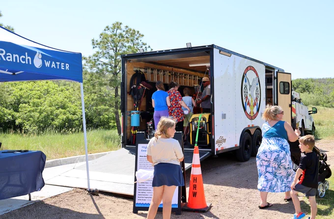Highlands Ranch Water's emergency response trailer at an outdoor event as people walk around it.