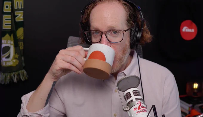 Robby drinks from a ceramic mug