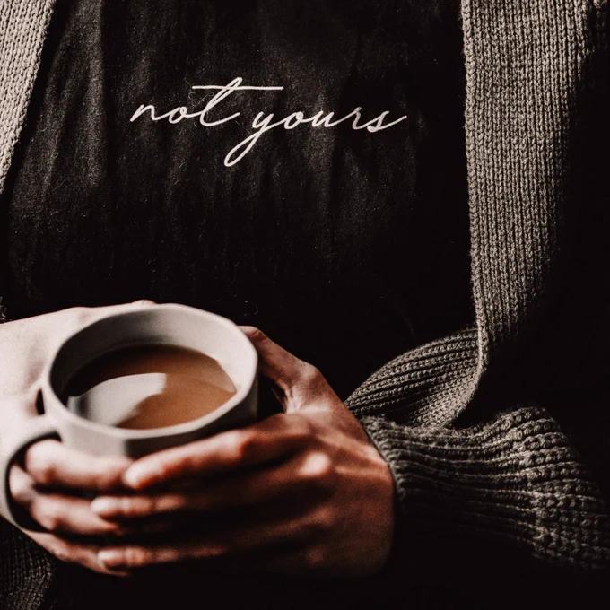 Woman with a coffee and a tshirt that says not yours.