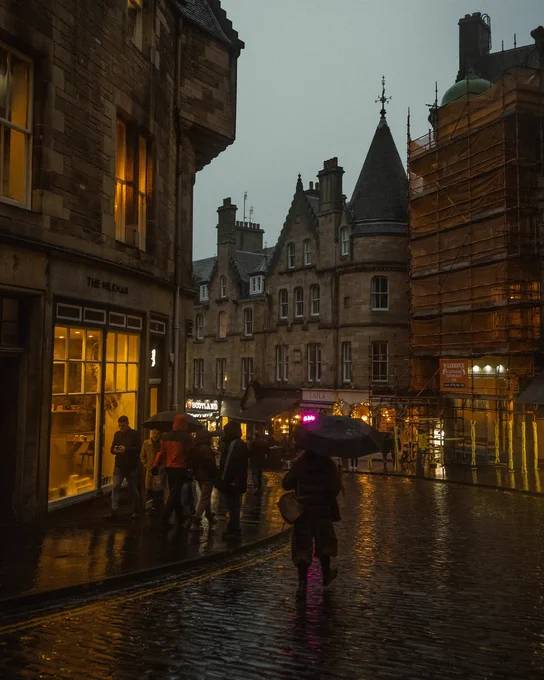 Four rainy evening scenes in Edinburgh featuring historic streets, warm lights reflected on wet pavement, old stone buildings, umbrellas, and a distant city skyline above autumn-colored trees.

Photography by Viktorija Peciulyte (@charmingwanders)