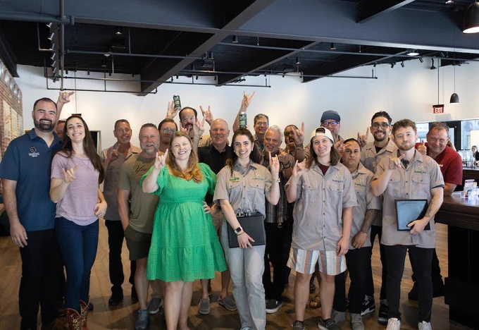 New graduates pose with USF administrators, faculty and community partners during the most recent graduation ceremony for USF's Brewing Arts program.
