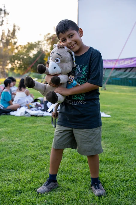 Child poses with prize at movie night.
