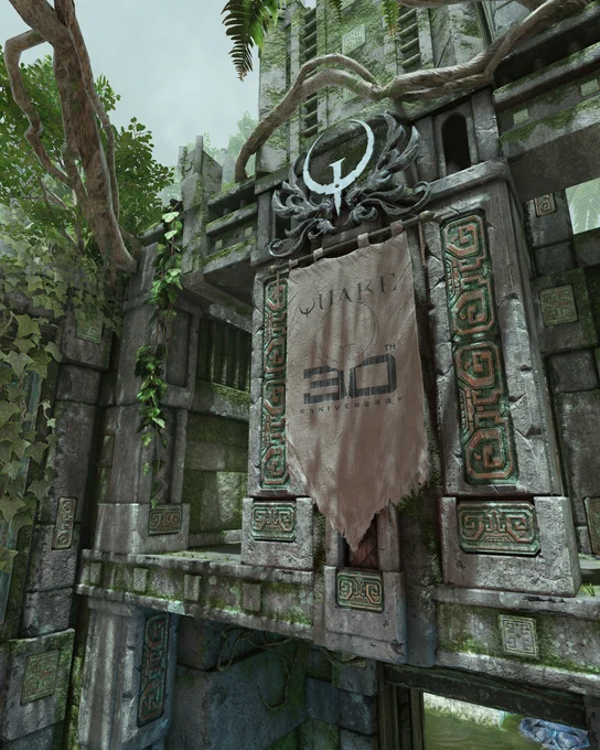 An ancient stone structure adorned with intricate carvings and lush green vines. In the center, there is a tattered banner displaying the text 'QUAKE 30TH ANNIVERSARY' with a logo above it. The scene is bright with a cloudy sky.