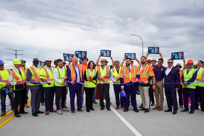 Gov. Whitmer cuts a ribbon alongside road workers, and community and business leaders.