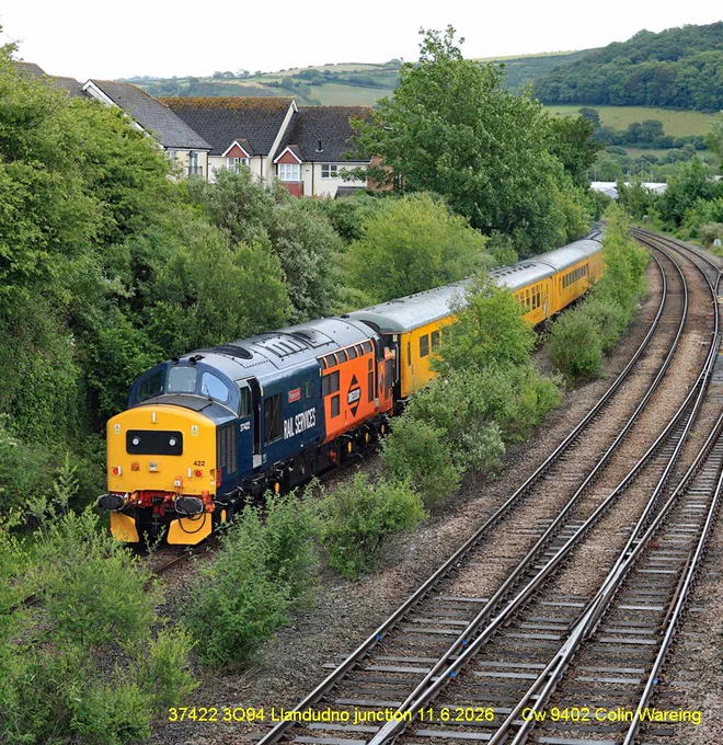 HNRC Swietelsky Deisel locomotive Class 37 No.37422 has just passed Llandudno Junction station at the rear of an ultrasonic test train.
The train started from Bangor in North Wales and is returning to Derby, conducting tests on the track below the carriages as it goes.  
The train came from Derby the day before and stabled over night in Bangor. 
On the front of the train is another class 37 locomotive, Colas no 37099.  
37422 is owned by HNRC Swietelsky and carries a distinctive half orange and half blue livery.
The test train is running under headcode or train reporting no 3Q94.
11.6.26
Image Cw 9402 copyright Colin Wareing of Colin and Carole’s Creations
