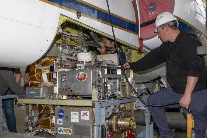 Mechanic Francisco Rodriguez and crew chief Darin Whittington installed the Airborne Visible/Infrared Imaging Spectrometer (AVIRIS) instrument into a NASA ER-2 high-altitude aircraft at NASA’s Armstrong Flight Research Center in Edwards, California, on Wednesday, March 11, 2026. Credit: NASA/Jim Ross