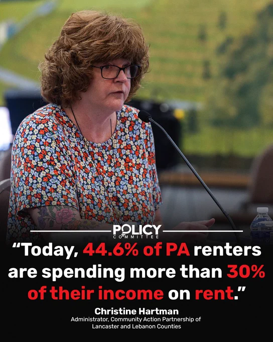 Christine Hartman, Community Action Partnership administrator, speaks at a Policy Committee hearing with quote overlay.