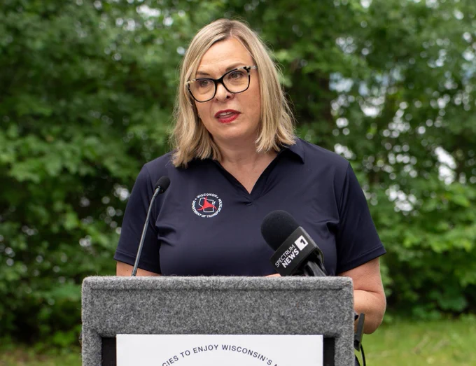 WisDOT Secretary Kristina Boardman speaking at podium with trees in background