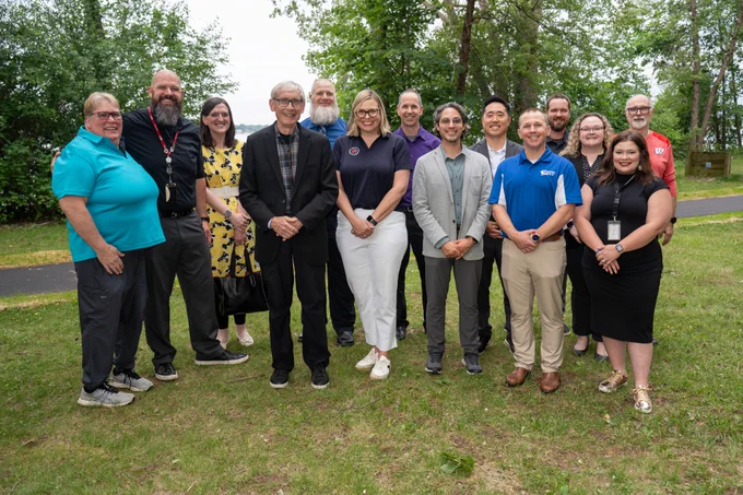 WisDOT Secretary Boardman and Governor Tony Evers pose for photo with members of the Wisconsin DMV with trees in background