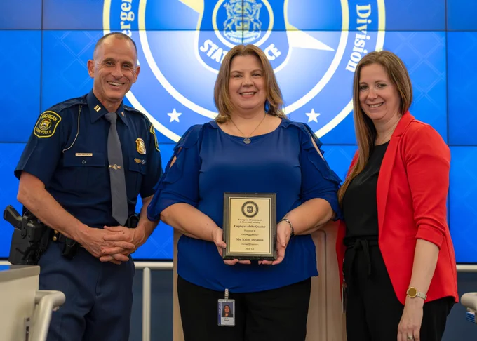 woman holding employee of the quarter award with emhsd leadership 
