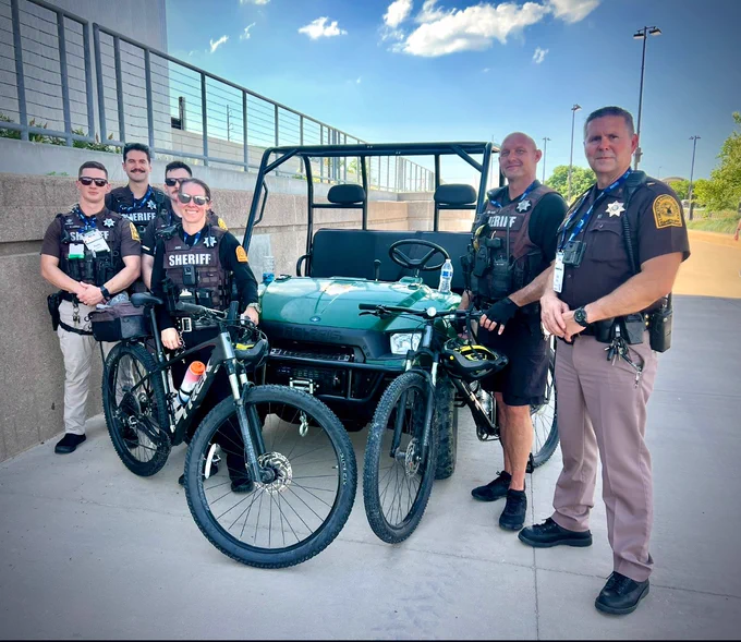 Deputies in uniform standing next to bikes for bike patrol.