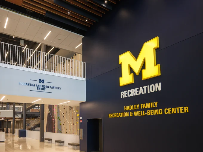 A bright maize Block M with the words Recreation and Hadley Family Recreation & Well-Being Center against a blue wall