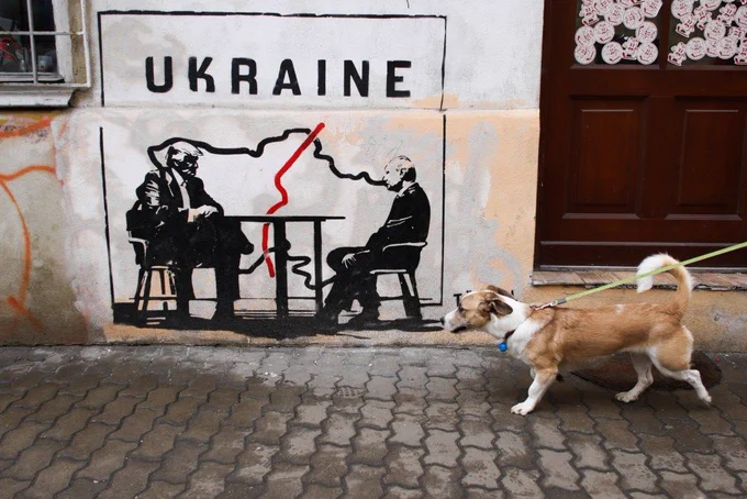 Street art depicting Donald Trump and Vladimir Putin making a deal on Ukraine