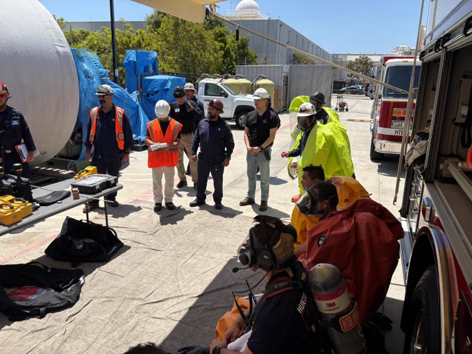 HBFD Hazardous Materials Team members and facility representatives gather around monitoring and detection equipment during a training session at a local industrial business. Participants review response procedures, hazard assessments, and mitigation strategies.