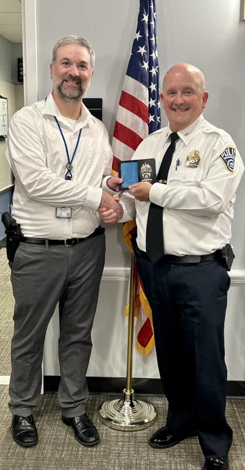 Corporal Tuomey receives his retirement badge from Chief Penn.