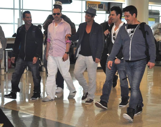 A group of five people walking together in an airport terminal. 