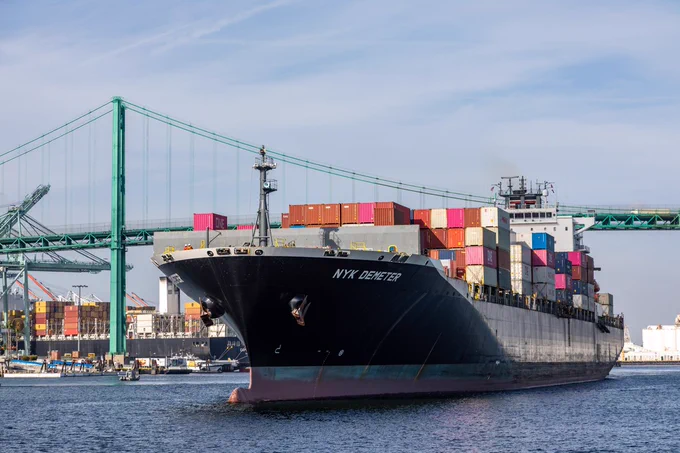 Container ship moves under the Vincent Thomas Bridge at the Port of Los Angeles 
