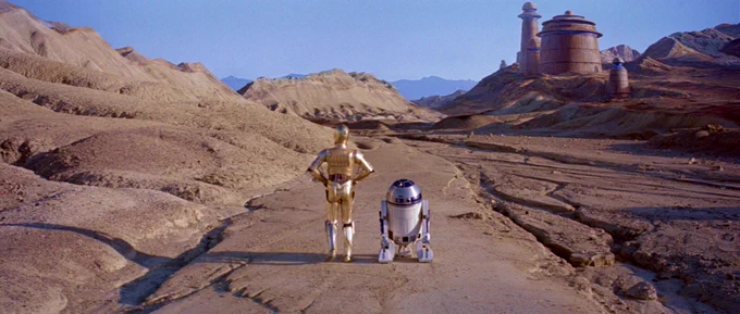 3PO and R2 head toward Jabba's palace along the sandy road