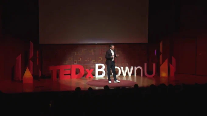 Still image of Dr. Greven onstage, with the \"TEDxBrownU\" block letters behind him
