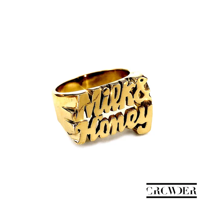 Album Art of Crowder's Milk And Honey album - On a white background, in the middle is a gold ring that has 'Milk and Honey' etched into the top of the ring. In the bottom right, there are two black bars with a 'Crowder' word mark between them, in all caps with some of the vertical bits of letters missing.