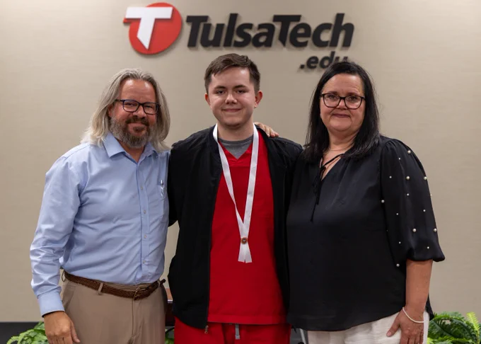 Student poses with family at nursing pinning ceremony
