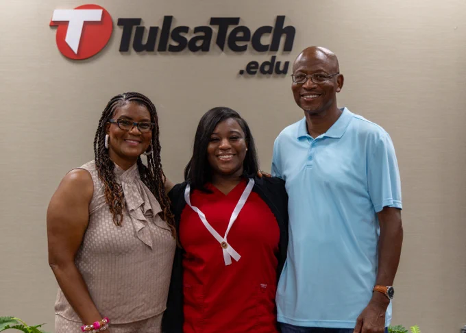 Student poses with family at nursing pinning ceremony