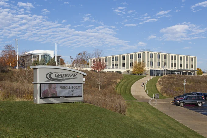 Gateway Racine Campus with a digital sign encouraging enrollment and a modern academic building under a partly cloudy sky.