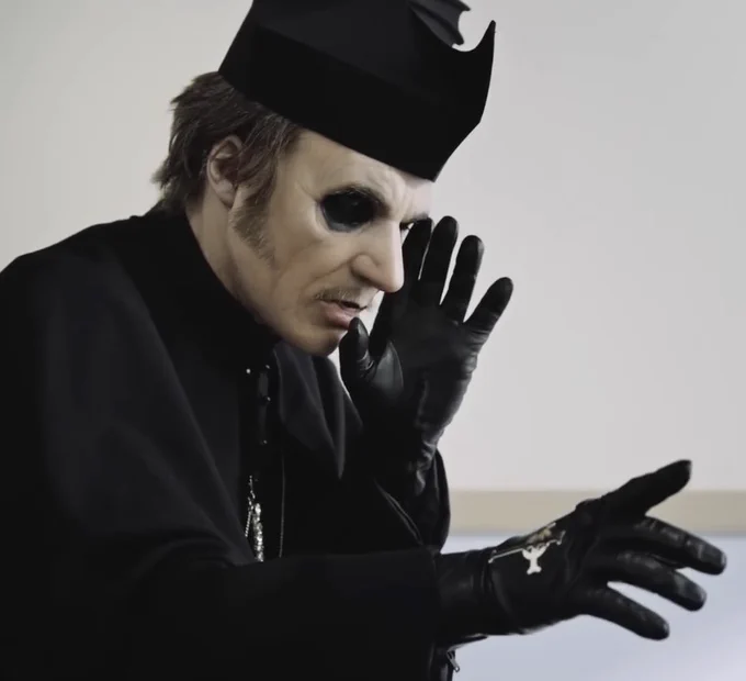 Picture of Cardinal Copia from chapter 6. It shows him from the chest up, standing in a hospital room and turned to the right. One hand is held up to his face with the other reaching out to the right. He’s wearing a black cassock and biretta.
