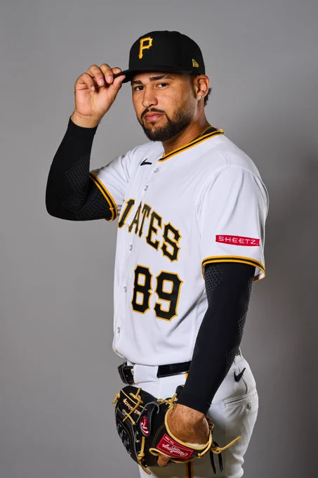 Antwone Kelly touches the brim of his black Pittsburgh Pirates hat with his right hand while wearing a white uniform with the number 89 on the front.