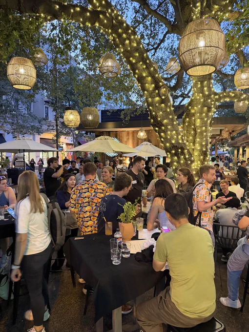 A crowd of people enjoy the twilight with drinks