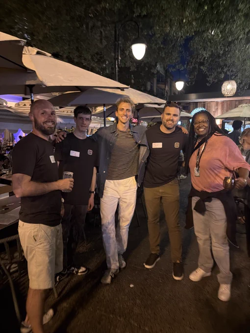 Five smiling people pose