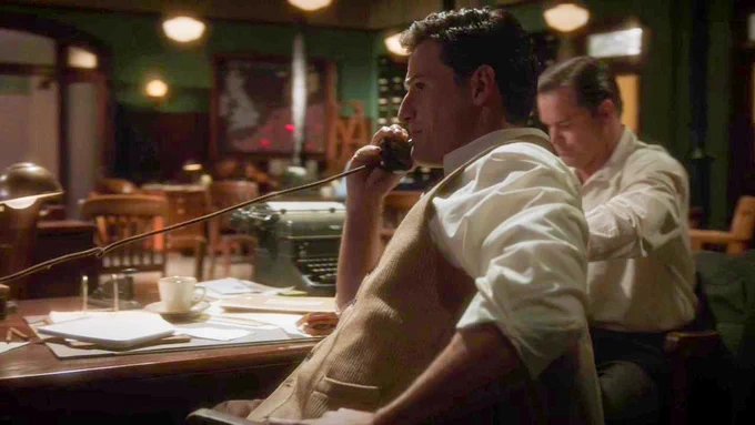 daniel sousa talking on the phone while seated at his desk in the bullpen of the s.s.r. new york office in "agent carter"