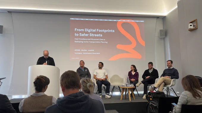 Panel discussion on digital footprints and safer streets with five seated speakers and one presenter at a podium in a modern conference room.